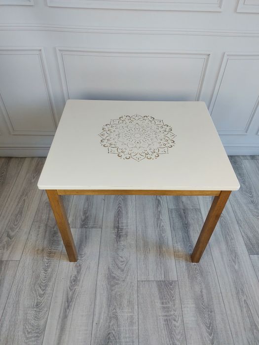 Biały stolik kawowy z drewnianymi nogami