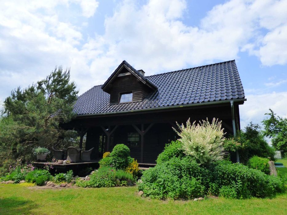 Urokliwy dom w otoczeniu zieleni z własnym stawem.