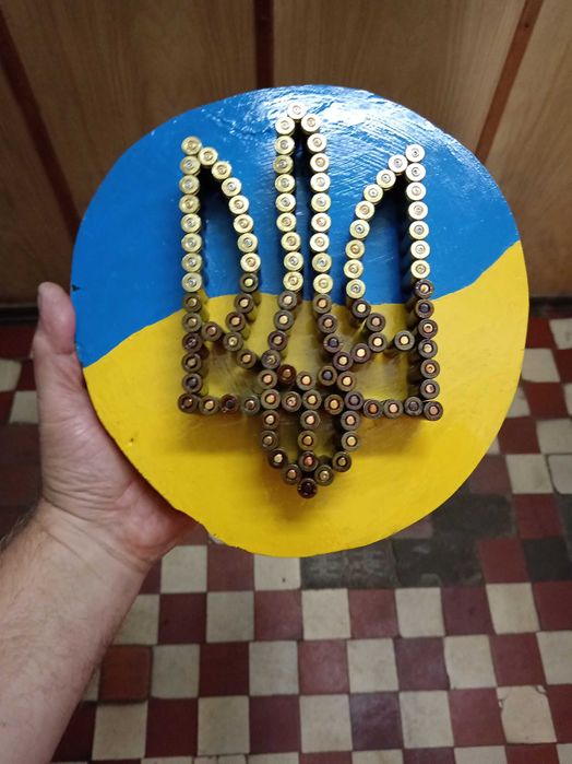 Герб України на зрізі дерева вибиті із стреляних гільз.