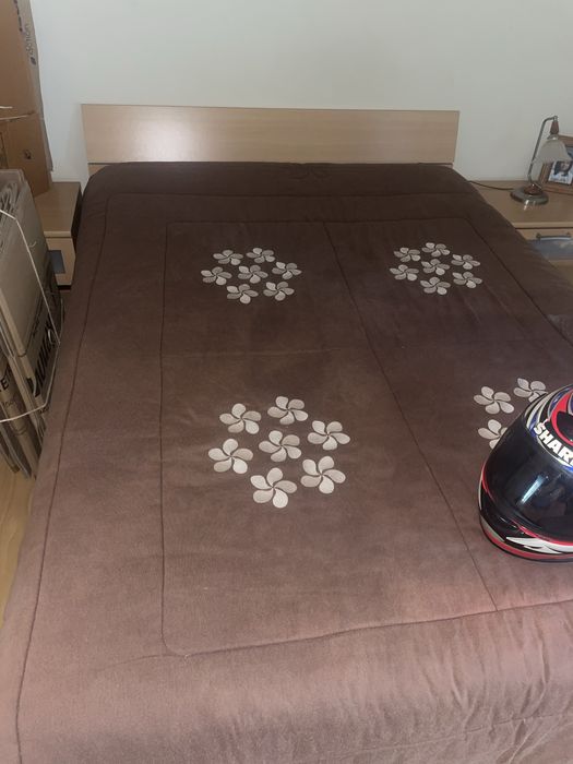 Cama sem colchão com mesinhas de cabeceira e comoda