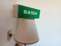Placa saída de emergência verde em bom estado tem cobre a trabalhar