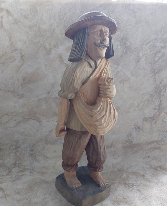 Duża, drewniana rzeźba przedstawiająca postać w tradycyjnym stroju, pr