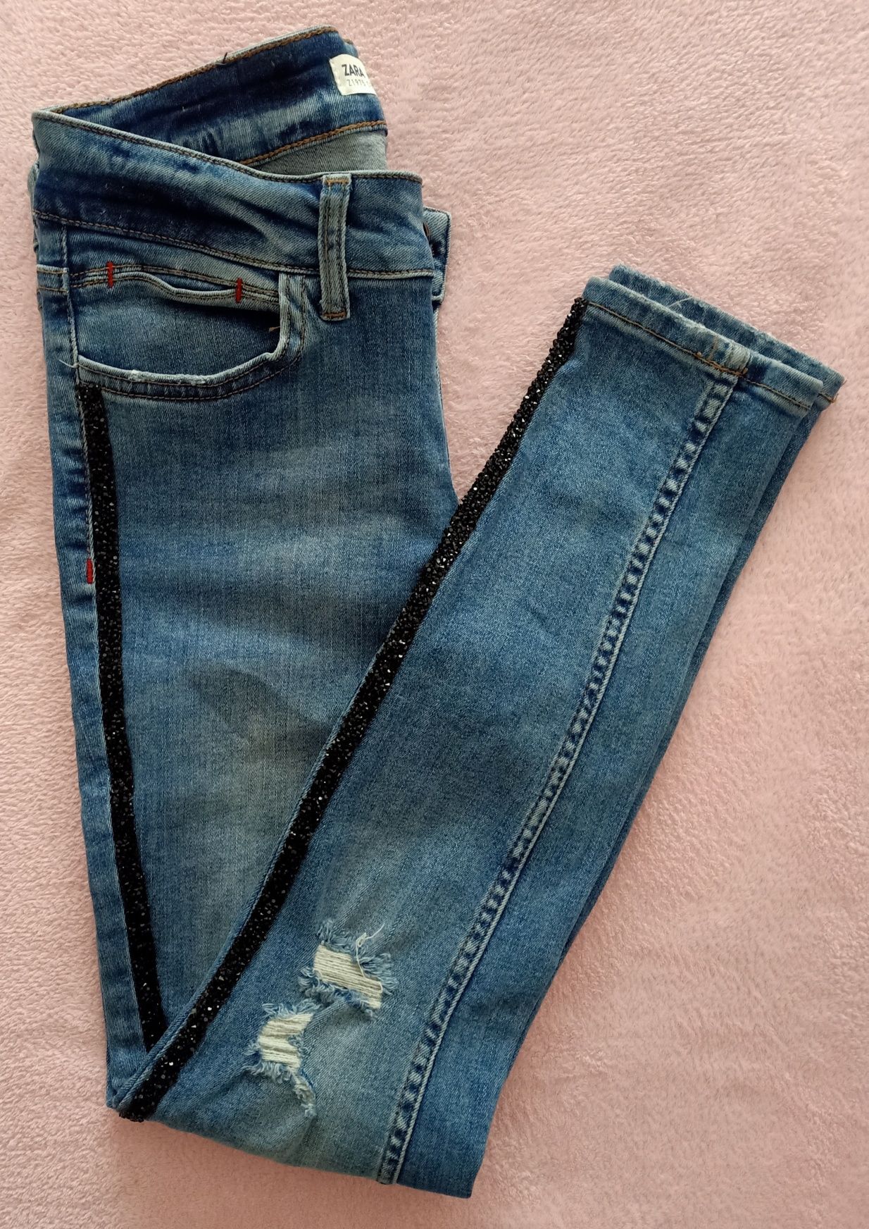 Skinny jeans com rasgões e brilhantes laterais Zara