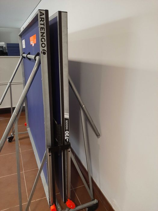 Mesa de ténis com raquetes e bolas