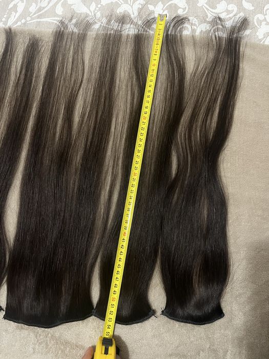 Extensões castanhas escuras de cabelo verdadeiro.