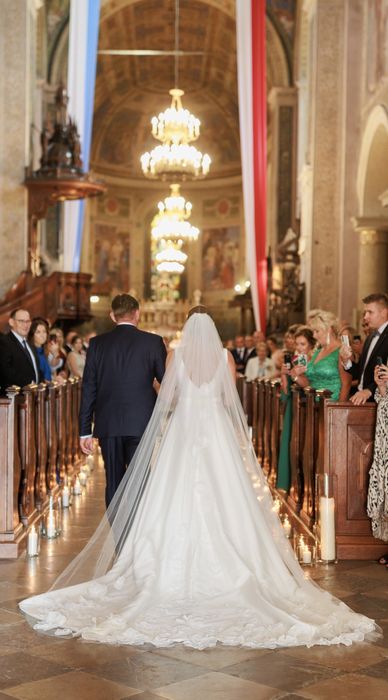 Spektakularna elegancka gładka suknia ślubna. Tren i welon