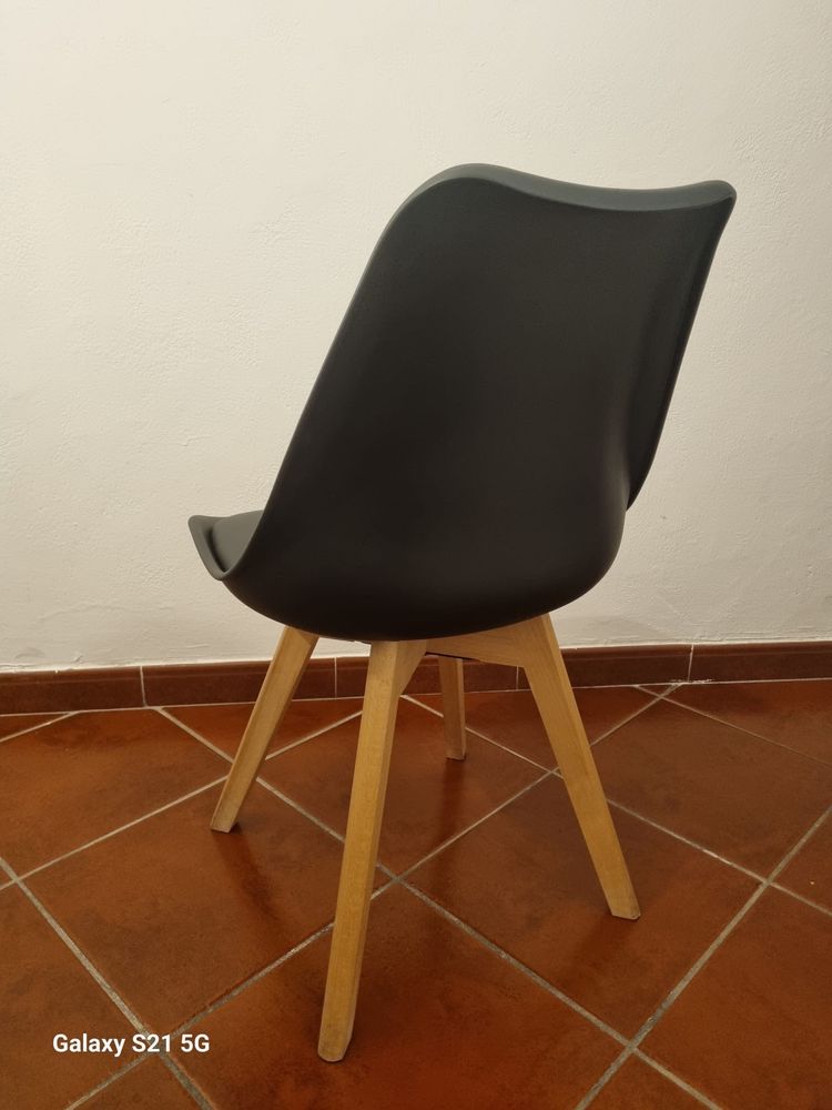 Cadeiras pretas com pés em madeira