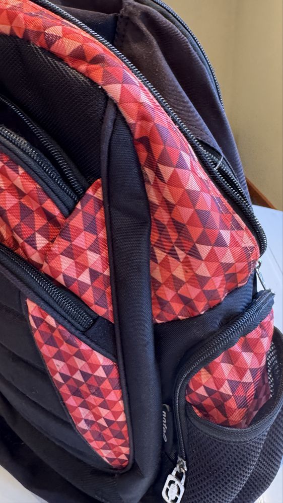 Mochila preta e vermelha com imensos bolsos