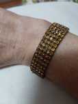 Pulseira prateada com brilhantes dourados