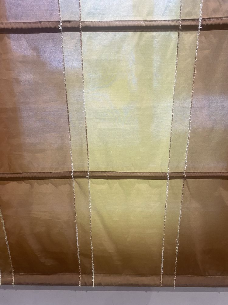 Cortinas de cor beje e tijolo leve com duas almofadas iguais