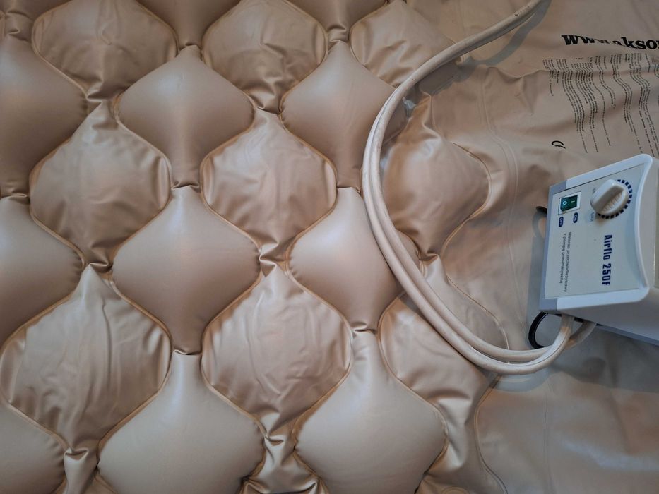 Materac przeciwodleżynowy z pompą pneumatyczną.