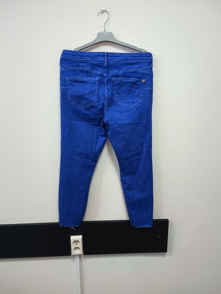 Niebieskie jeansy rurki spodnie z dziurami