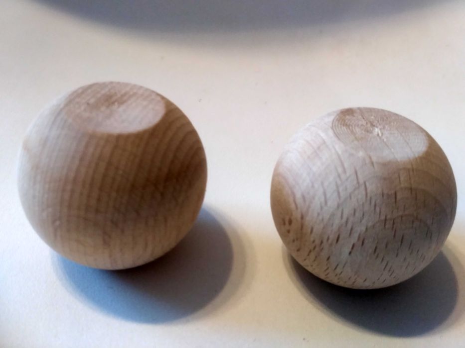 dwie drewniane gałki kulkowe, głowy lalek,