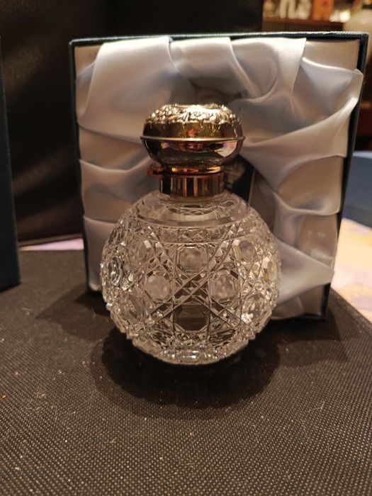 Флакон для духов с серебряной крышкой.