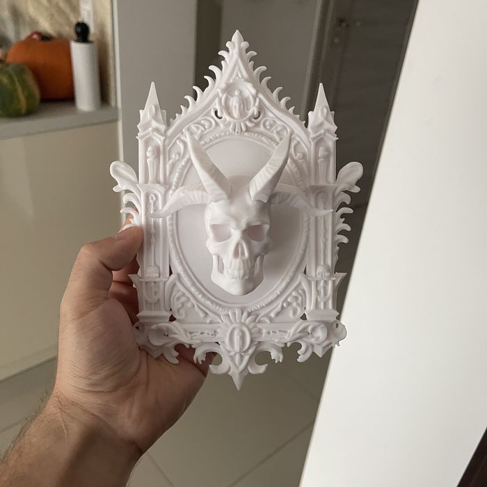 Gotycka płaskorzeźba czaszki w białej ramie – dekoracja ścienna 3D