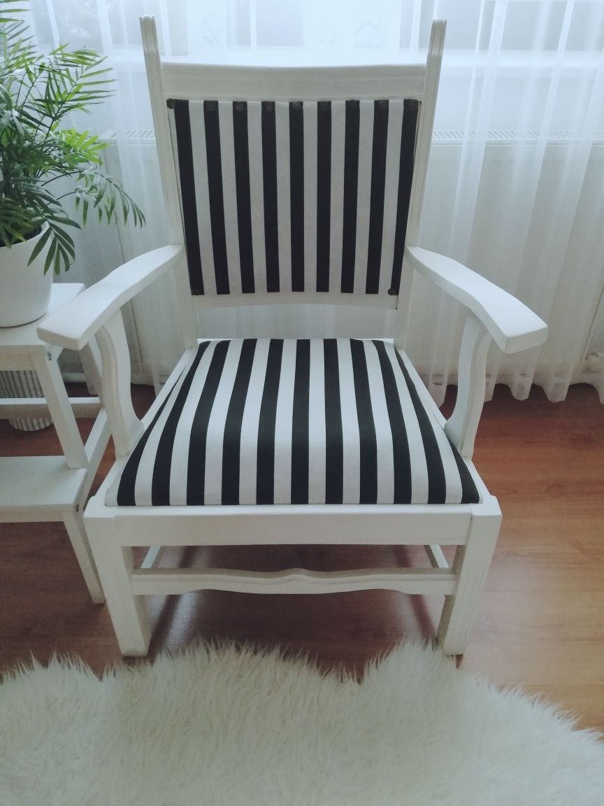 Drewniany biały fotel w biało-czarne pasy.