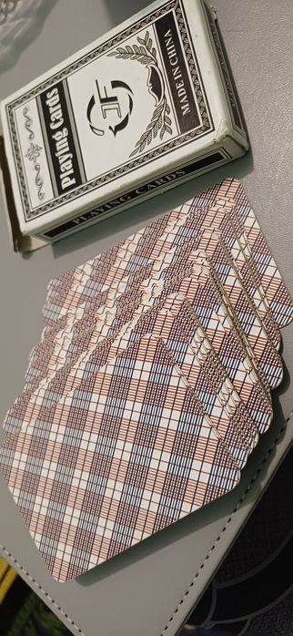 Колода игральных карт с клетчатым узором на обратной стороне. 
Игральн