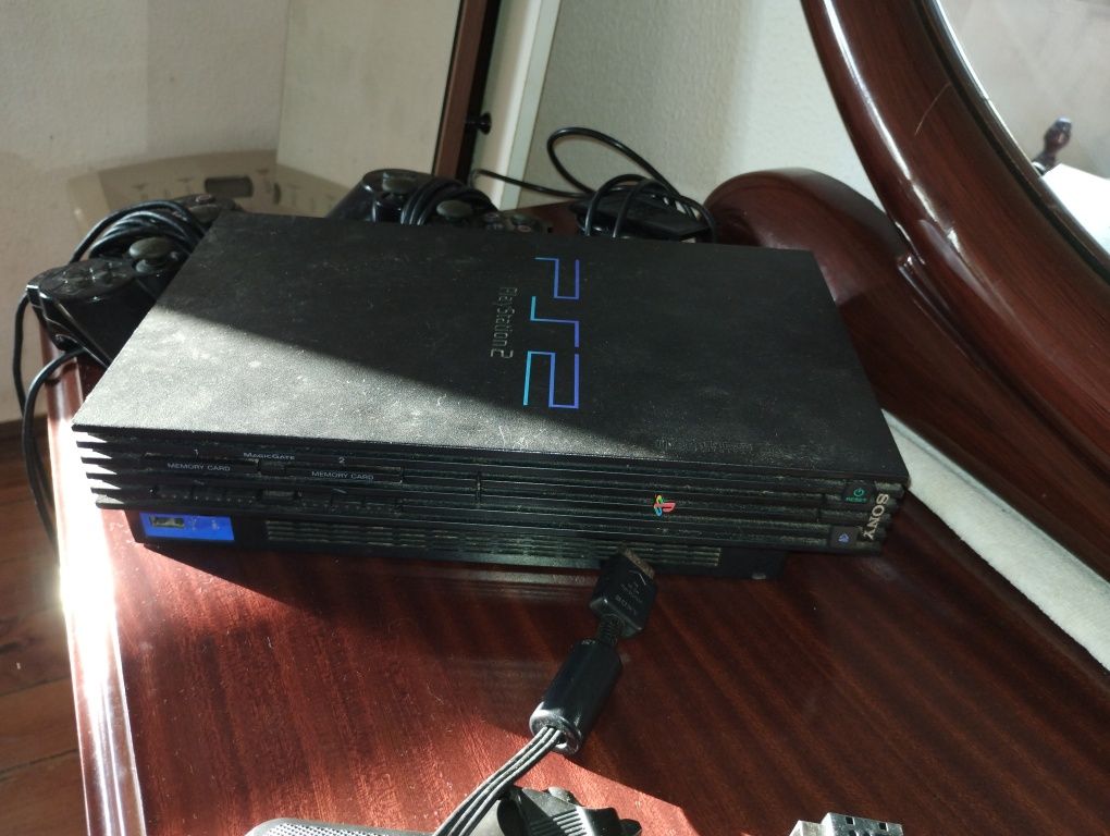 PlayStation PS2 preta com volante, pedais, câmara