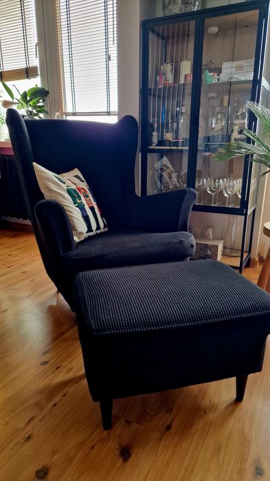 Fotel Uszak IKEA musztardowy z czarnym pokrowcem.