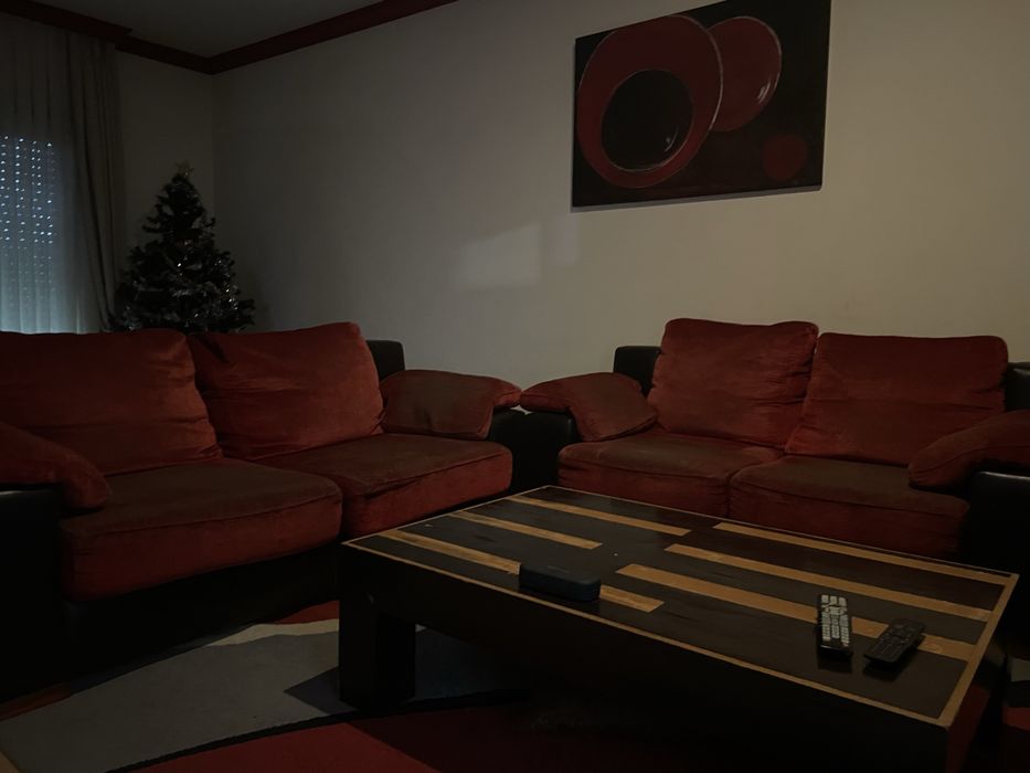 Dois sofás vermelhos com algum uso