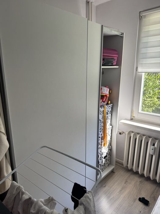 Szafa przesuwna biala z pólkami i wieszakiem.