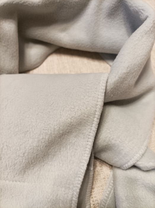 Szalik z polaru w jasnym kolorze.