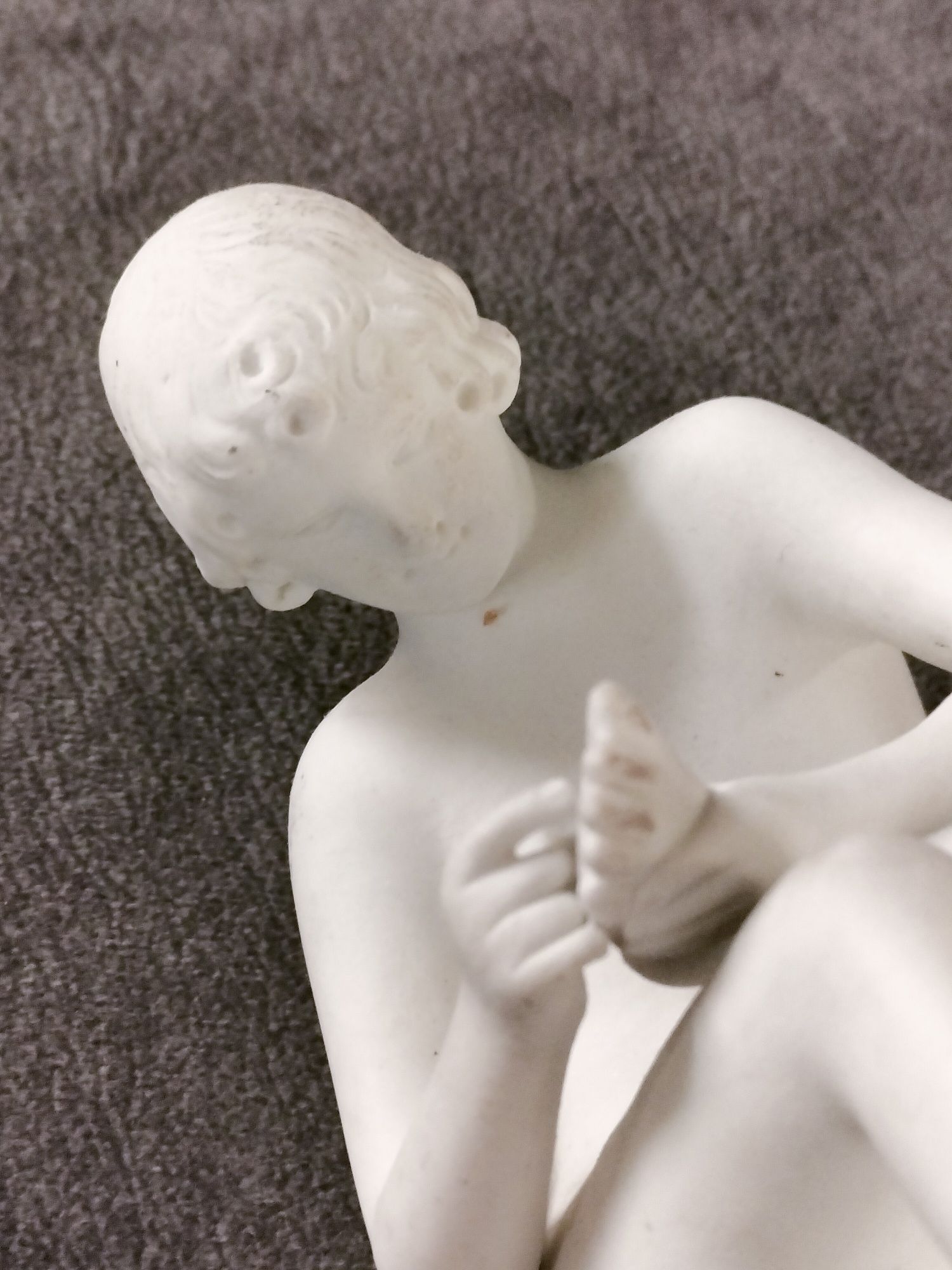 Porcelanowa figurka spinelio chłopiec z kolcem.