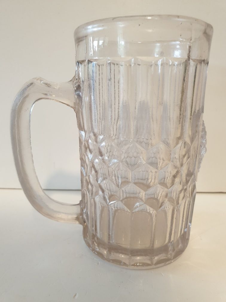 Antiga caneca de cerveja com cabeça de leão em vidro prensado