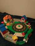 zabawka grająca firmy fisher price-rondo z  otaczającymi ją budynkami