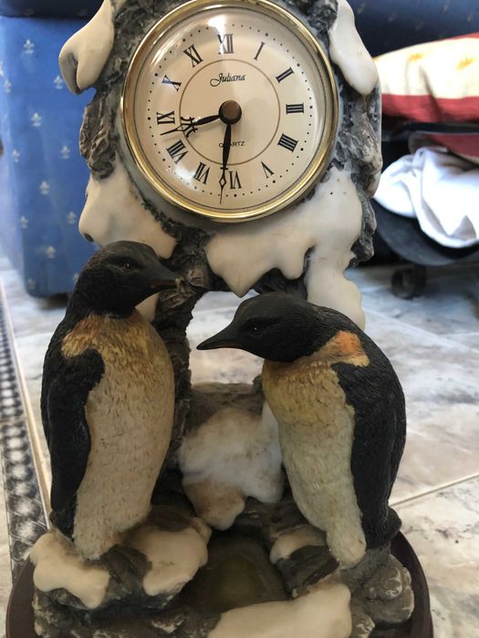 Relógio com estátua de pinguins