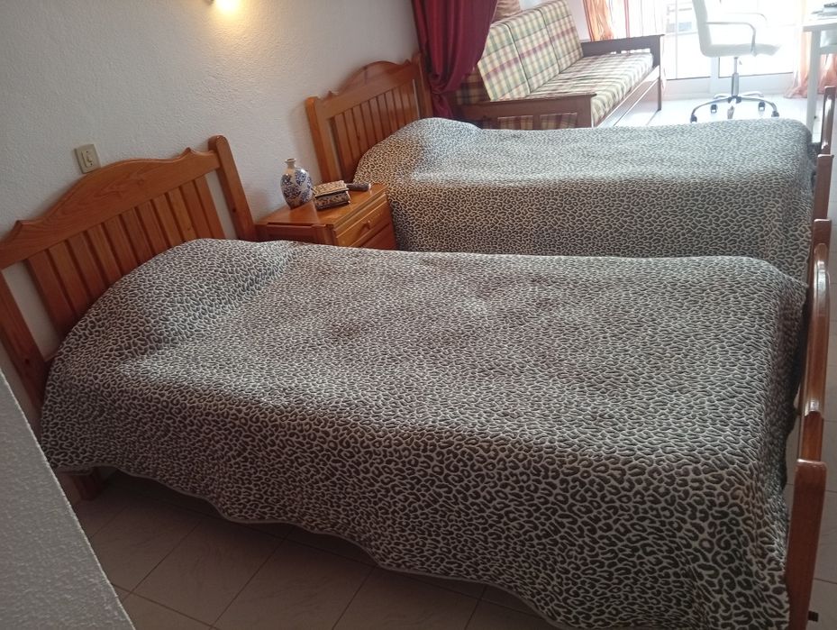 Duas camas de solteiro com uma mesa cabeceira