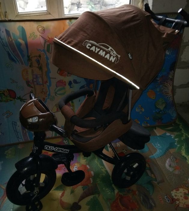 Продам детский музыкальный  велосипед-коляска Cayman.