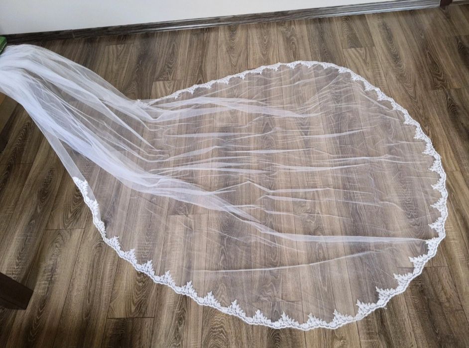 Długi biały welon katedralny zdobiony koronką, wyszywany koralikami