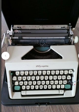 Stara mechaniczna maszyna do pisania Olympia z futerałem.