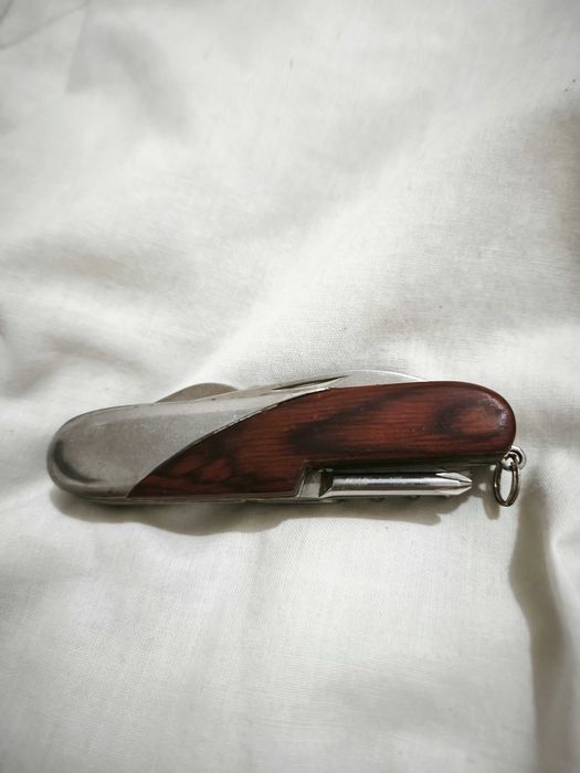 Canivete multifunções com acabamento em madeira e metal.