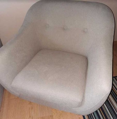 Duży wygodny fotel w kolorze jasno szarym.