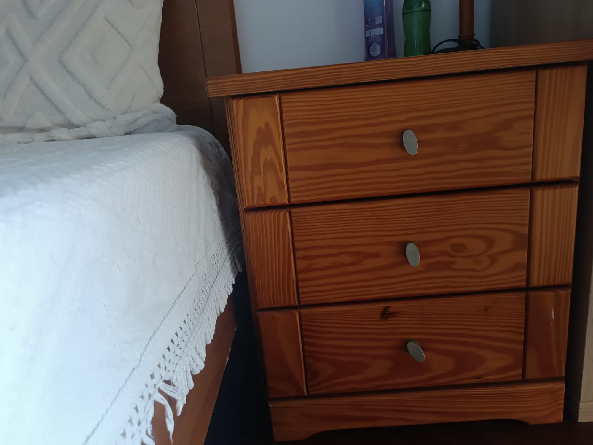 Uma cama 2 cabeceiras e um aparador de 4 gavetas.