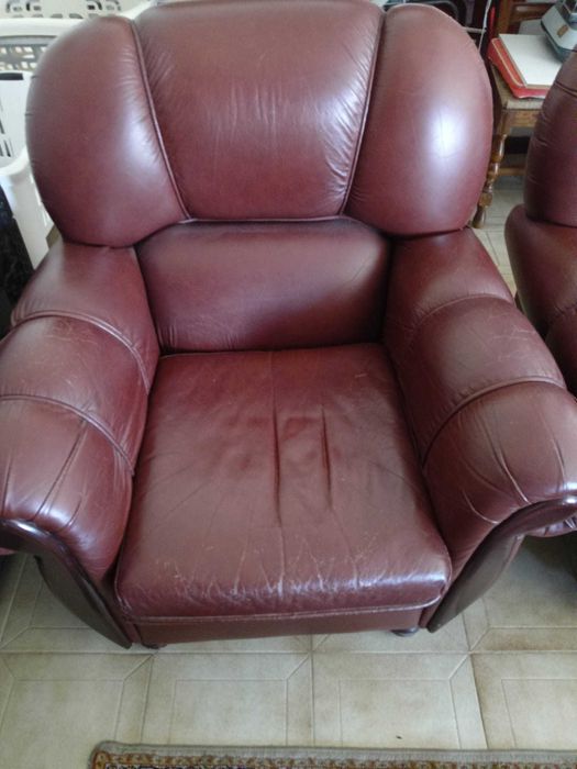 Sofá de três lugares e 2 poltronas em couro castanho.