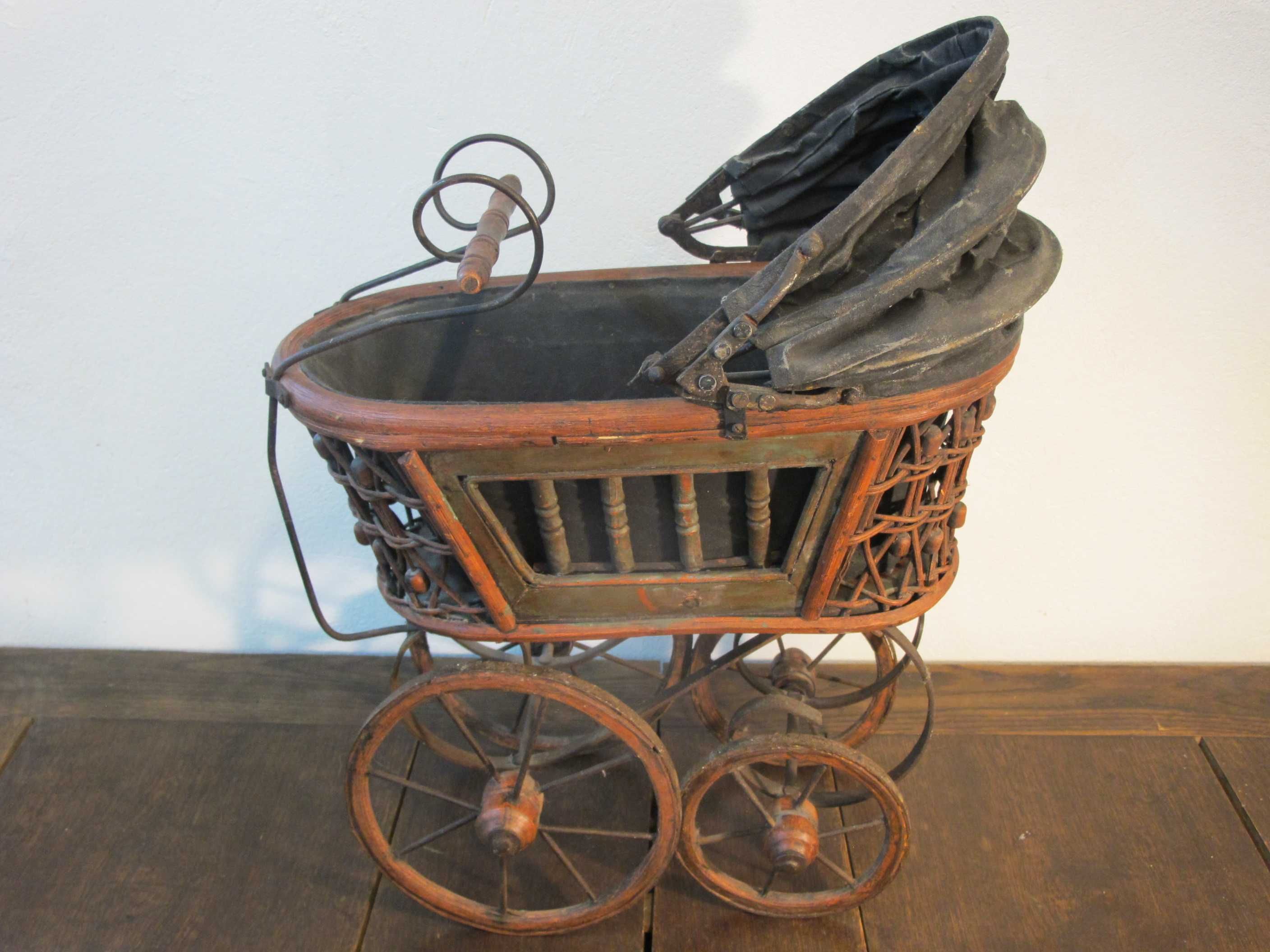 Stary zabytkowy wózek dla lalek, drewniana konstrukcja i koła ozdoba