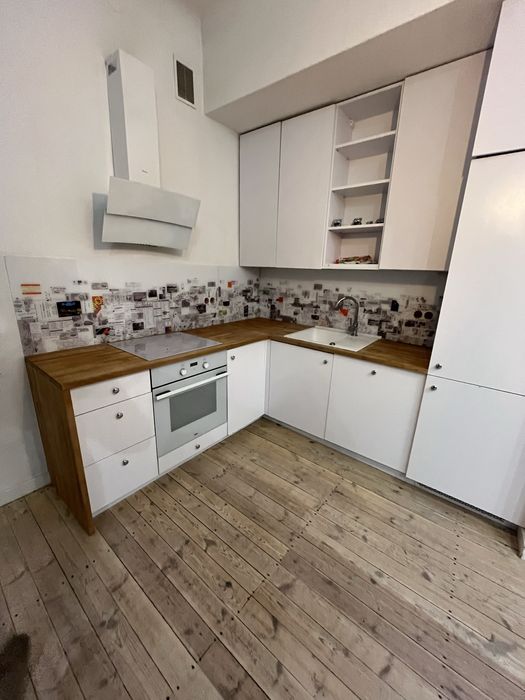 Białe meble kuchenne z agd, dębowy blat, lodówka, zmywarka, piekarnik