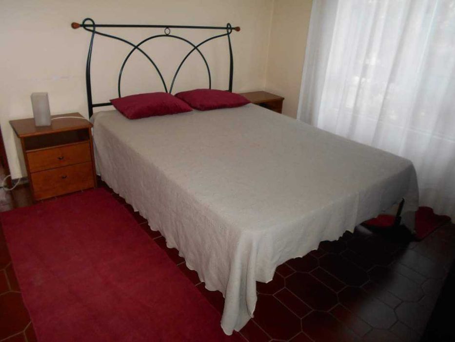 Cama com colchão e mesas cabeceira
