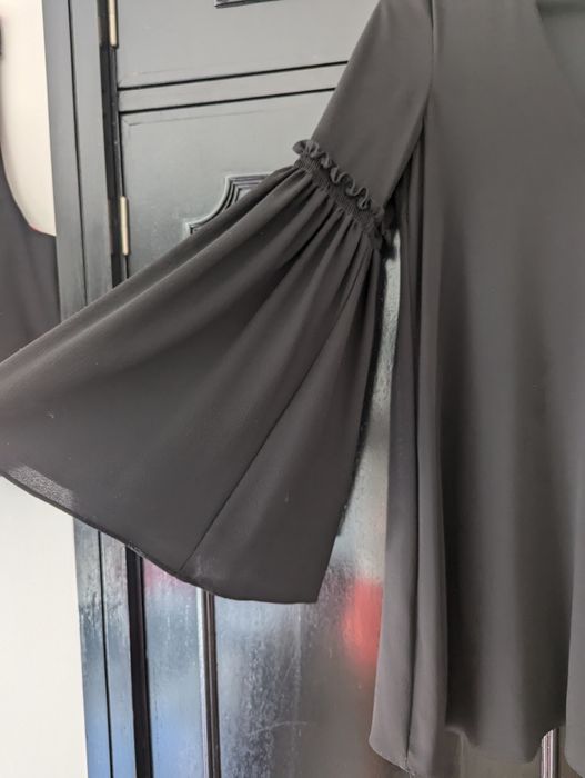 Vestido preto curto, com manga larga