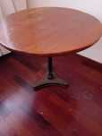 Pequena mesa de tampo redondo com pé em ferro forjado.