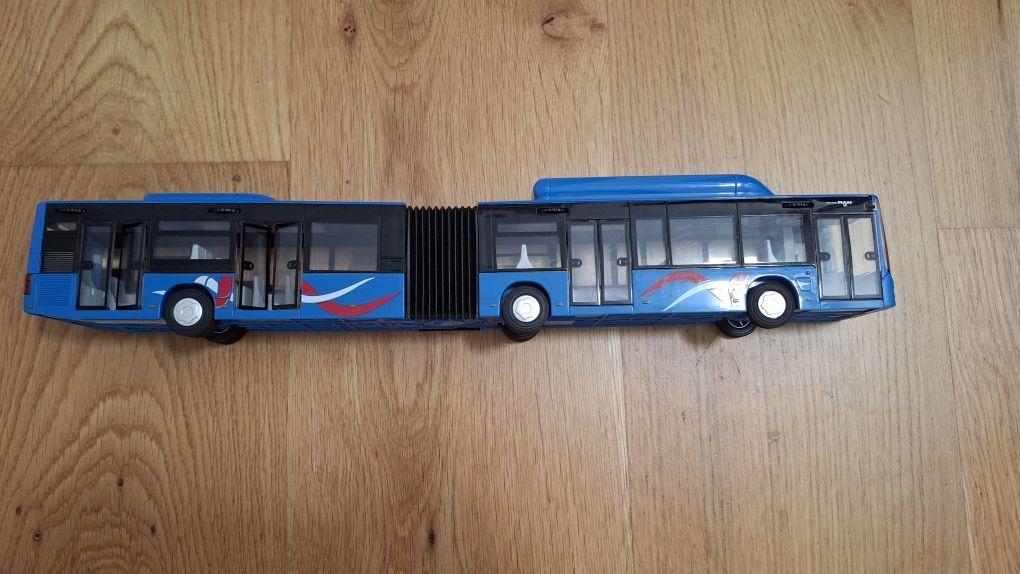 Długi niebieski przegubowy autobus Man