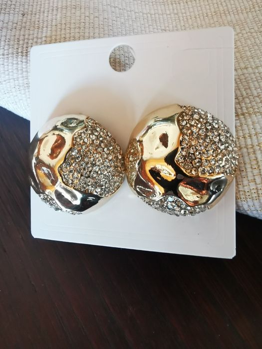 Brincos dourados com pedras brilhantes