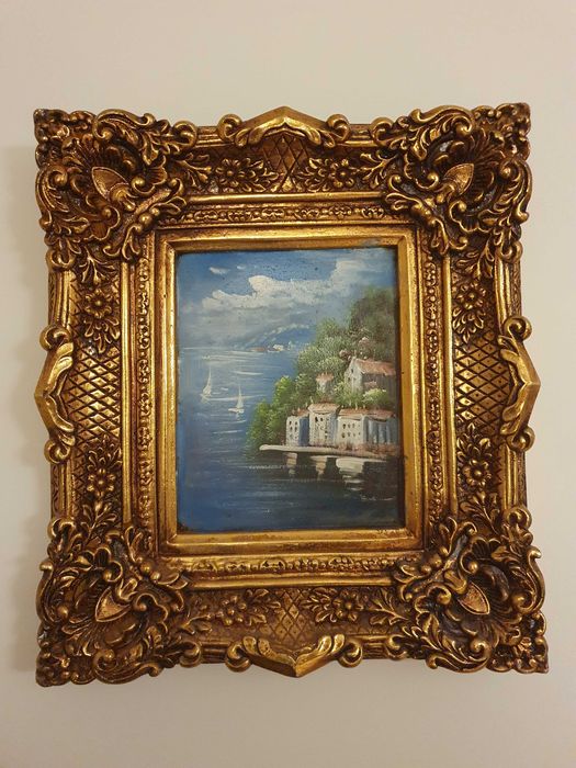 Obrazy i duże lustro z bogato zdobionymi ramami