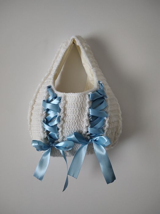biała torebka z niebieskimi wstążkami