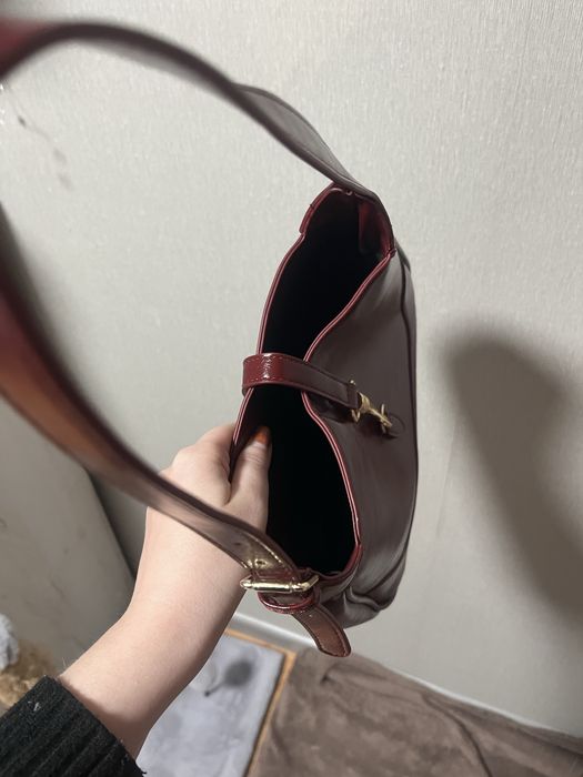 Сумка бордового кольору.