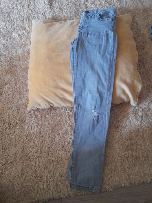 Calças de ganga de rapaz usadas em bom estado.