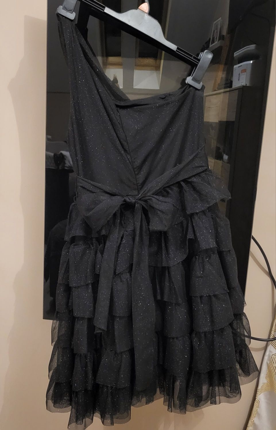 Czarna brokatowa sukienka z falbanami na jedno ramię